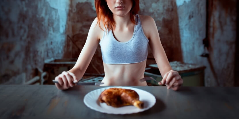 Худая-девушка-ест-курицу-питание-при-анорексии-Академия-Wellness-Consulting